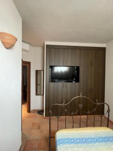 Camera con TV a parete e letto di Villa San Leonardo a Santo Stefano di Camastra