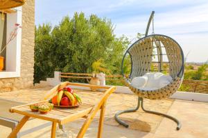 einen Stuhl auf einer Terrasse mit einer Schale Obst auf einem Tisch in der Unterkunft Villa Mama : comfort et hospitalité in Essaouira