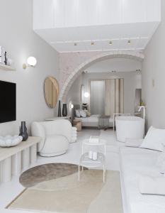 a living room with white furniture and a room with a bed at Amelia Luxury Suites Old Town in Chania
