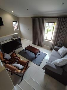 a living room with a couch and a table at Hilltop Guesthouse in Bellville