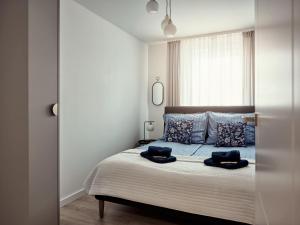 a bedroom with a bed with two pillows on it at A&W Apartament Zatoka Zwycięstwa - Rokosowo in Koszalin