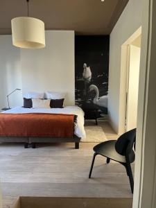 a bedroom with a bed and a chair and a table at Residence9Bruges in Bruges