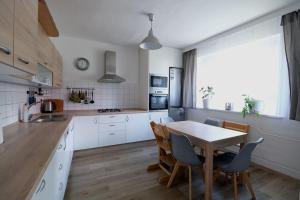 kuchnia z drewnianym stołem, stołem i krzesłami w obiekcie Ostrava, byt 80 m2 v RD w Ostravie