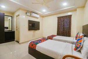 FabHotel Champion Residency في بانغالور: غرفة فندقية بسريرين وتلفزيون