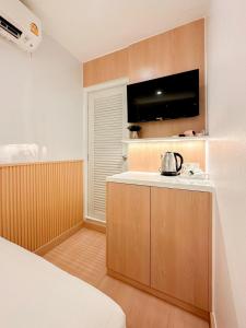 een kamer met een bed en een keuken met een waterkoker bij Thrive Hotel in Bangkok
