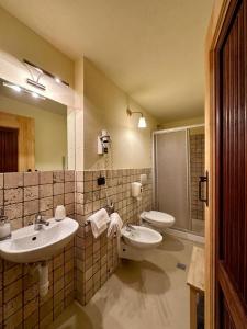 a bathroom with two sinks and a mirror at Maison Rosset agriturismo, CAMERE, appartamenti e spa in Valle d'Aosta in Nus