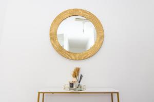 a mirror on a white wall with a table at Central Home in Milton Keynes in Milton Keynes