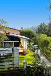 a house with a fence in front of it at LEELA's COUNTRY HOUSE in Kodaikānāl