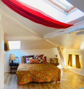 - une chambre avec un lit et un plafond rouge dans l'établissement Spacieux Studio Seventies: voyage dans le temps, à Gannat