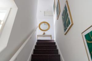una escalera con fotografías en las paredes y un espejo en Central Home in Milton Keynes, en Milton Keynes