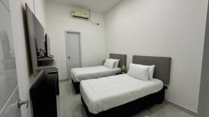 a small room with two beds and a tv at Rio Hotel Centro in Leticia
