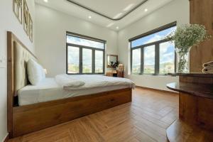 um quarto com uma cama e 2 janelas grandes em Villa Trung Nghĩa 36 em Ấp Ða Lợi