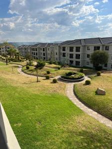 an apartment complex with a lawn and a building at Azure Escape - Power backup in Sandton
