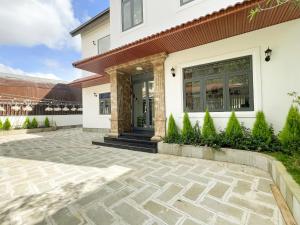 a house with a stone patio in front of a building at Villa Trung Nghĩa 36 in Ấp Ða Lợi