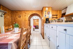 a kitchen with wooden walls and a table and a table sidx sidx sidx at Chez les Charles in Bernex