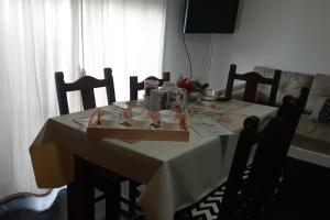 uma mesa de jantar com uma toalha de mesa branca e cadeiras em ALOJATE CATALEIA dep 1 EZEIZA PLENO CENTRO A 12 MINUTOS DE AEROPUERTO MINISTRO PISTARINI em Ezeiza