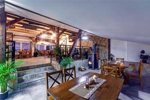 a restaurant with a table and chairs and a fireplace at Apartamenty Bieszczady in Lesko