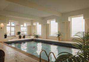 a swimming pool in a building with windows at Atlantic Hotel Newquay in Newquay
