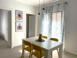 uma sala de jantar com uma mesa branca e cadeiras em Volturno3 Suites & more em Mazara del Vallo