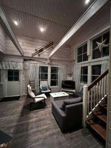 a large living room with a couch and chairs at Ruka Cottage in Kuusamo