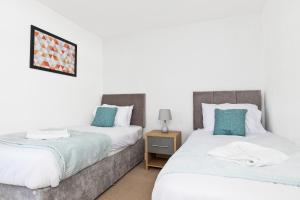 two beds sitting next to each other in a bedroom at OPP B'ham - Freshly refurbished walls and carpets! BIG SAVINGS booking 7 days or more! in Marston Green