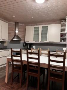 eine Küche mit einem Tisch und Stühlen in einer Küche in der Unterkunft Ruka Cottage in Kuusamo