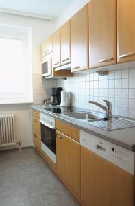 a kitchen with wooden cabinets and a sink at City Appartement Salzburg in Salzburg +5 photos