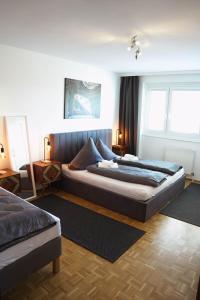 two beds in a room with two windows at City Appartement Salzburg in Salzburg