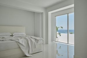 a white bedroom with a bed and a window at OLYN VILLAS in Nikiti +41 photos