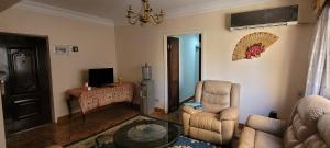a living room with a couch and a chair and a table at Cozy 3BR Place Nasr City in Cairo