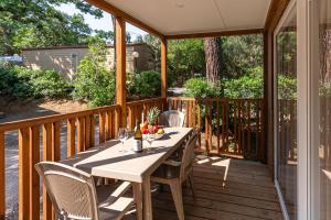 a wooden deck with a table and chairs at Club del Sole Stella del Mare Family Collection in Castiglione della Pescaia
