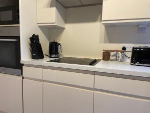 a kitchen with white cabinets and a counter top at The wing at Old Hundred in Tormarton