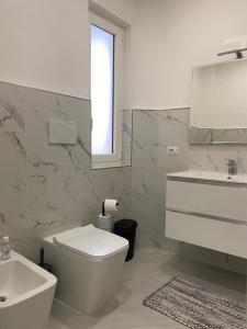 ein Badezimmer mit einem WC, einem Waschbecken und einem Spiegel in der Unterkunft Due Golfi Heart in Massa Lubrense
