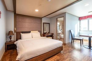 una camera con letto, scrivania e tavolo di Namiltte Resort a Sacheon