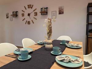 a table with plates and a clock on the wall at Ferienwohnung Naturraum in Losheim