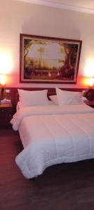 two beds in a hotel room with a painting on the wall at Drini Hotel in Durrës