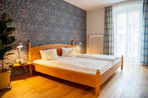 a bedroom with a bed with a wooden headboard at Biohotel Alte Post in Müllheim