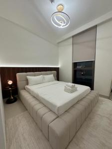 een slaapkamer met een groot wit bed in een kamer bij Luxury Apartment Burj Crown Burj Khalifa View in Dubai