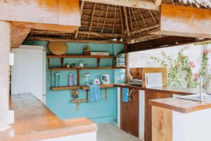 una cocina con paredes azules y estanterías de madera en Bukoba Villas - Olive - Private Pool, AC & Wi-Fi en Nungwi