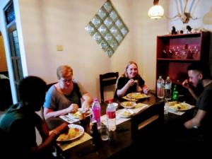 Eine Gruppe von Menschen, die an einem Tisch sitzen und Essen essen. in der Unterkunft Green turf in Galle