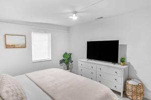 um quarto com uma cama e uma televisão numa cómoda em Central, Cozy Retreat em Vero Beach