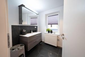 a bathroom with a sink and a mirror at NEW modernes Loft im Zentrum von Deggendorf in Deggendorf
