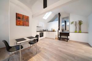 a kitchen and living room with a table and chairs at NEW modernes Loft im Zentrum von Deggendorf in Deggendorf