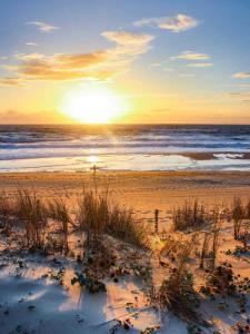 um pôr-do-sol numa praia com o oceano em Résidence Escale Océane T2 42 m2 à 500 m de la Plage em Capbreton