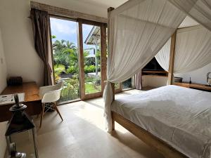 una camera con letto, scrivania e finestra di Villa Bodhi Kulture - Huge 4BR Luxury Villa for families & groups in Canggu - Bali a Canggu