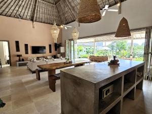 un soggiorno con divano e tavolo di Villa Bodhi Kulture - Huge 4BR Luxury Villa for families & groups in Canggu - Bali a Canggu