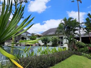 una villa con piscina di fronte a una casa di Villa Bodhi Kulture - Huge 4BR Luxury Villa for families & groups in Canggu - Bali a Canggu
