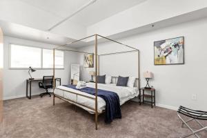 Un dormitorio con una cama con dosel y un escritorio. en Modern Downtown Apartment 2BR 2BA by CozySuites, en Indianápolis 17 fotos más