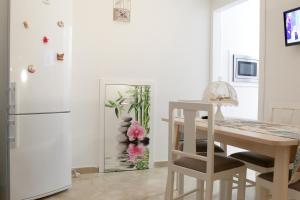 a kitchen with a table and a refrigerator at Appartamento Alla Corte dei Misteri in Trapani
