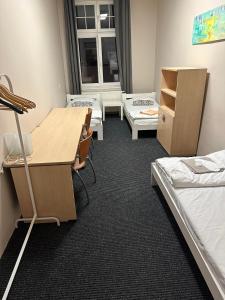 a dorm room with beds and a desk and a table at Chilli Hostel in Wrocław